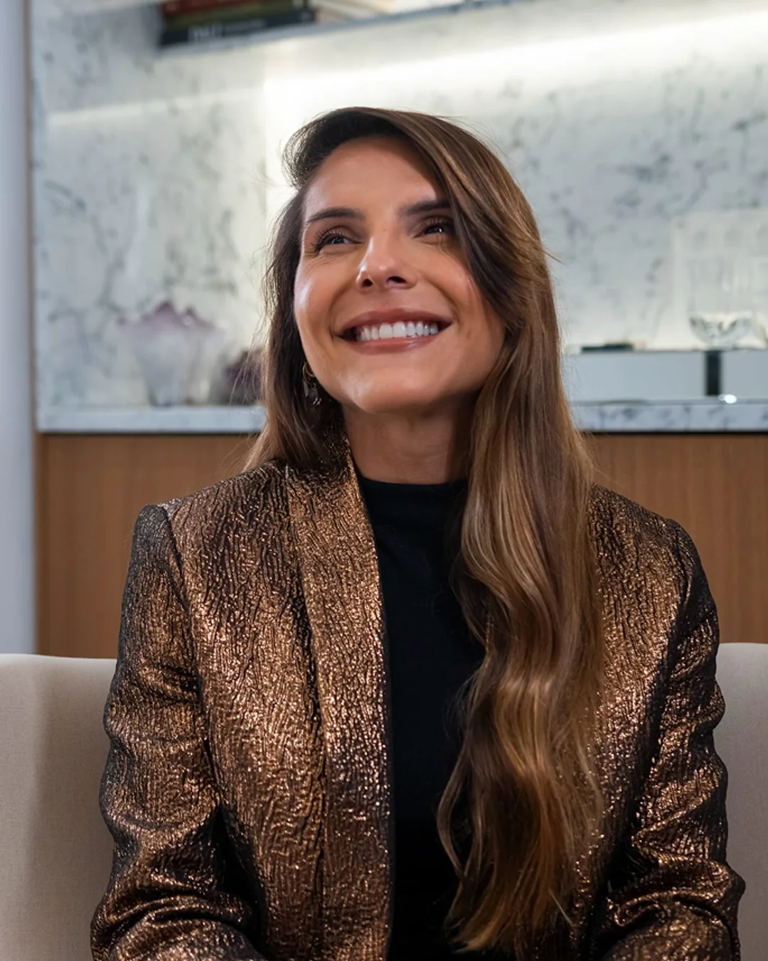 Dra. Jéssica Cardoso sorrindo, sentada no consultório